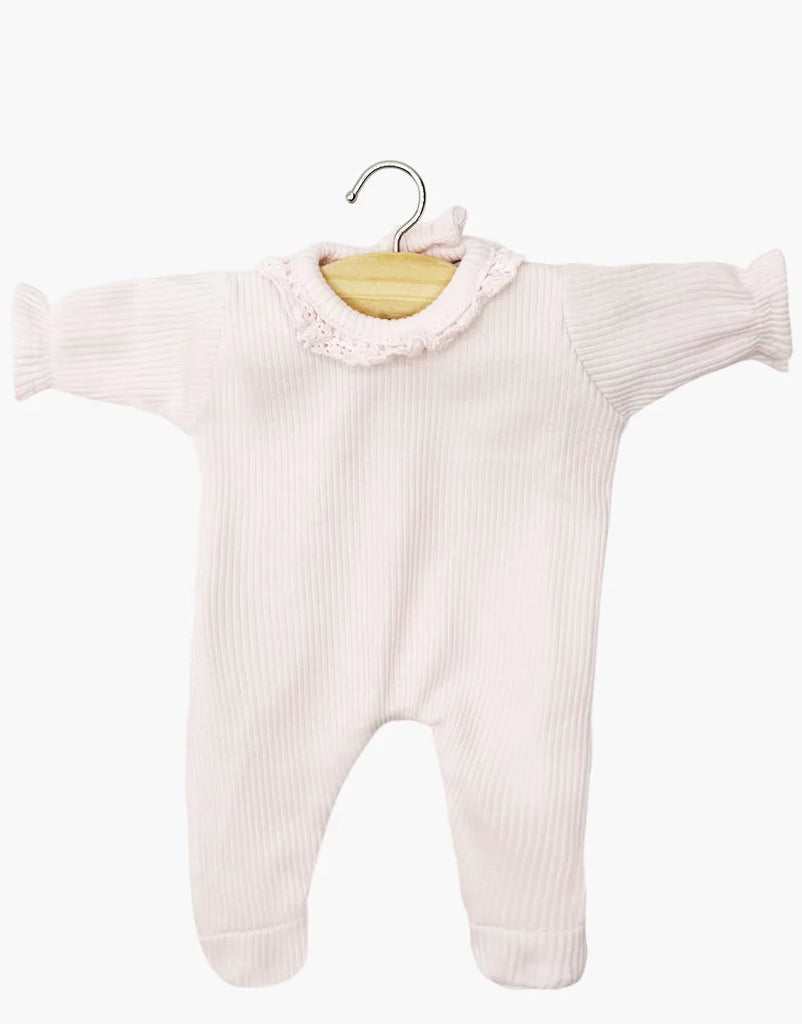 The Minikane 11" Doll Camille Onesie in pastel pink features ribbed knit cotton, lace trim, and long sleeves. Made in France, it's displayed on a wooden hanger against a white background.