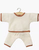 The Minikane 11" Doll Clothing Cocoon Jogger Set in honeycomb-knit ecru cotton has long sleeves and brown trim on the collar, cuffs, hem, and pant legs. Shown on a wooden hanger against a white background; fits Minikane dolls.