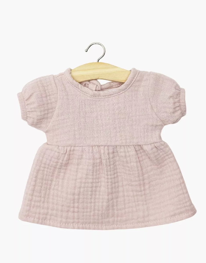 A Minikane 11" doll Faustine dress with balloon sleeves, made from orchid pink cotton gauze, hangs on a wooden hanger against a white background.