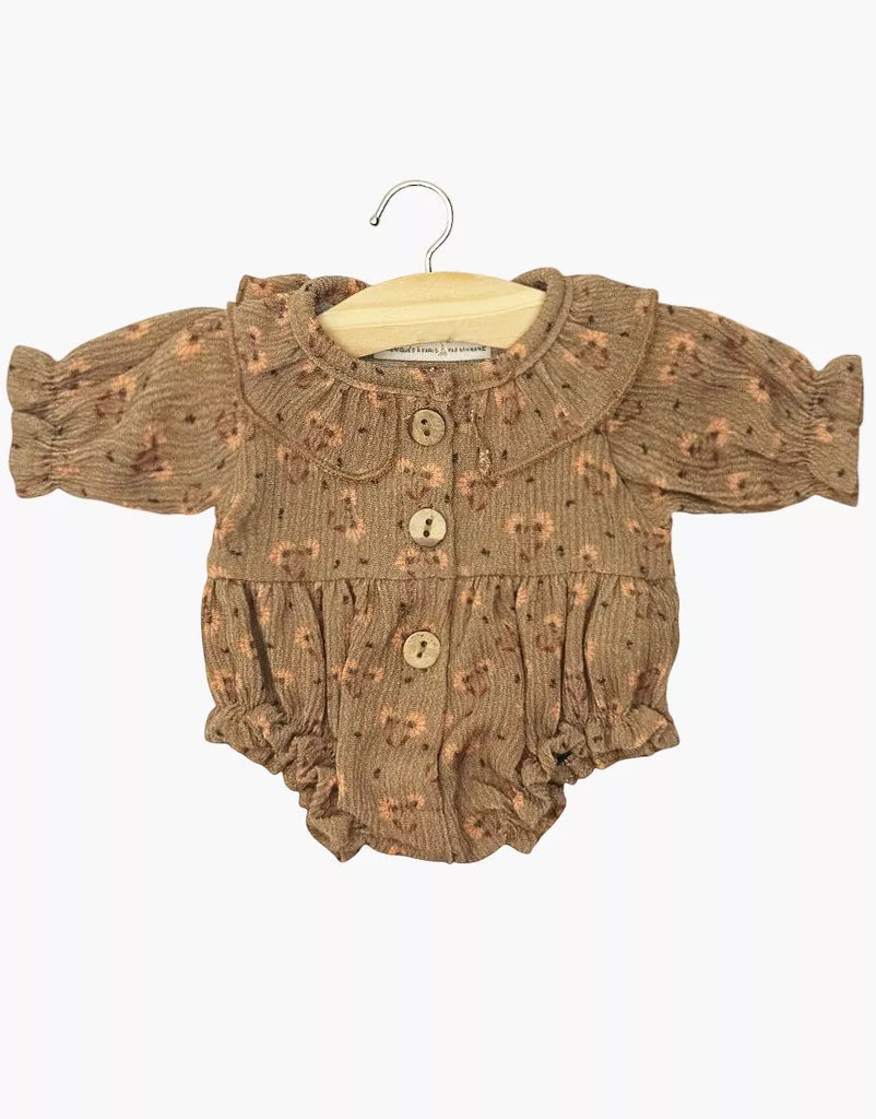 The Minikane Doll Clothing | Leonore Ruffled Romper in Crepe - Eloise features a brown crepe fabric, small floral print, long sleeves, wooden buttons, and ruffled collar and cuffs. Made in France for Gordis dolls; shown on a wooden hanger against a white background.