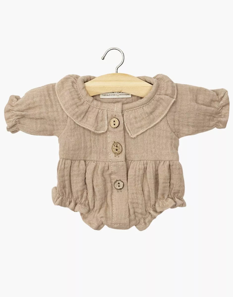 The Minikane Doll Clothing | Leonore Ruffled Romper in Cotton Gauze - Mocha is a mocha, long-sleeve romper with a Peter Pan collar and ruffled waist, designed for Minikane Gordis or 13" dolls, shown on a wooden hanger against a white background.