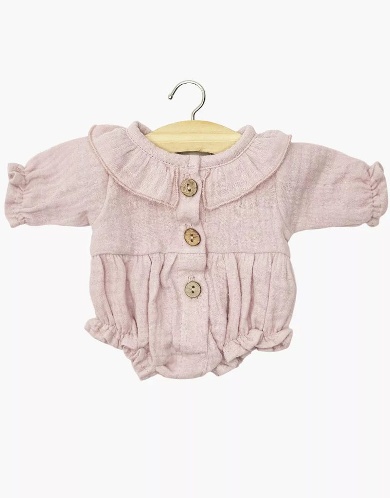 The Minikane Doll Clothing | Leonore Ruffled Romper in Cotton Gauze - Orchid Pink features long sleeves, a ruffled collar, wooden buttons, gathered cuffs, and ruffled leg openings—perfect for 13 inch dolls like Minikane. Displayed on a wooden hanger.