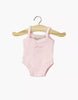The Minikane 13" Doll Clothing | Anna Leotard in Jersey Cotton - Pale Pink is displayed on a small wooden hanger against a plain white background. This light pink leotard is designed for 13-inch dolls like Minikane.