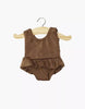 The Minikane 13" Doll Clothing Maïa Ruffled Leotard in soft lycra, chocolate brown, features a sleeveless design with waist ruffles, perfect for 13-inch dolls. Shown on a wooden hanger against a plain white background.