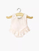 The Minikane 13" Doll Clothing | Maia Ruffled Leotard in Shiny Lycra - Pink is a light pink sleeveless onesie with a ruffled skirt, perfect for Minikane or 13 inch dolls, shown on a wooden hanger against a white background.