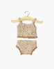 The Minikane Doll Clothing | Les P'tits Basiques 2-Piece Set in Jersey - Cocoa Flowers features a beige and light brown sleeveless top and matching bottoms with floral patterns, designed for Gordis dolls, shown on a wooden hanger against a white background.