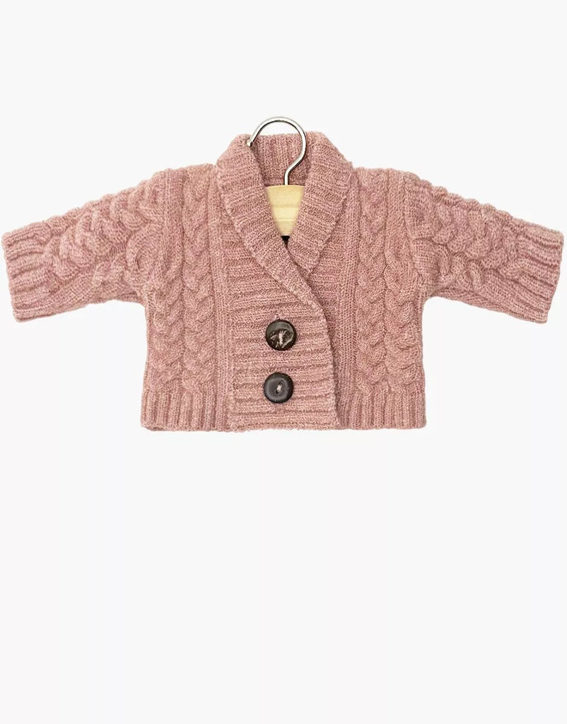The Minikane 13" Doll Clothing Gil Knitted Vest in Wool - Tea Pink features a shawl collar, cable knit pattern, ribbed cuffs and hem, and two brown buttons—perfect for Minikane dolls. Shown on a hanger against a white background.