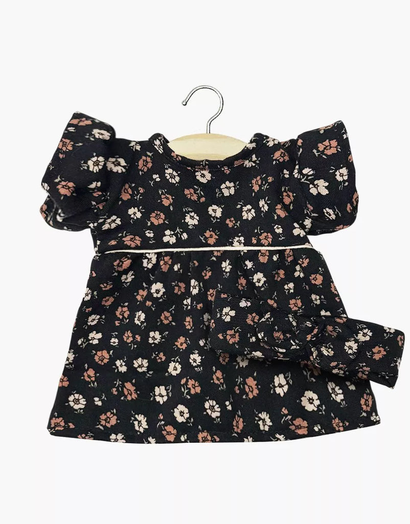 The Minikane Doll Clothing Rylee+Cru Daisy Dress and Headband - Capucine features a black floral dress with puffed short sleeves for 13-inch dolls, shown on a wooden hanger against a white background.