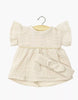 The Minikane 13" Doll Clothing | Daisy Dress & Headband in Cotton Gauze - Putty is a cream-colored outfit with short ruffled sleeves, designed for 13 inch or Minikane dolls. Shown on a wooden hanger against a white background.