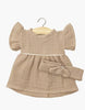 The Minikane 13" Doll Clothing set includes a mocha Daisy Dress and matching headband in cotton gauze, sized for 13-inch dolls like Minikane. Displayed on a wooden hanger against a white background.