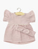 The Minikane Doll Clothing Daisy Dress & Headband in Cotton Gauze - Orchid Pink, featuring ruffled short sleeves and a gathered waist, is displayed on a wooden hanger against a white background. Perfectly sized for Minikane dolls.