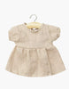 A nude linen Faustine dress with balloon sleeves for 11" Minikane dolls, displayed on a wooden hanger against a white background—ideal for dressing your Minikane Babies doll in style.