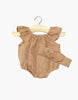The Minikane Doll Clothing | Clara Romper & Headband in Washed Linen - Hazelnut is a light brown, sleeveless romper with ruffled shoulders and matching headband for Minikane Gordis dolls, shown on a wooden hanger against a white background.