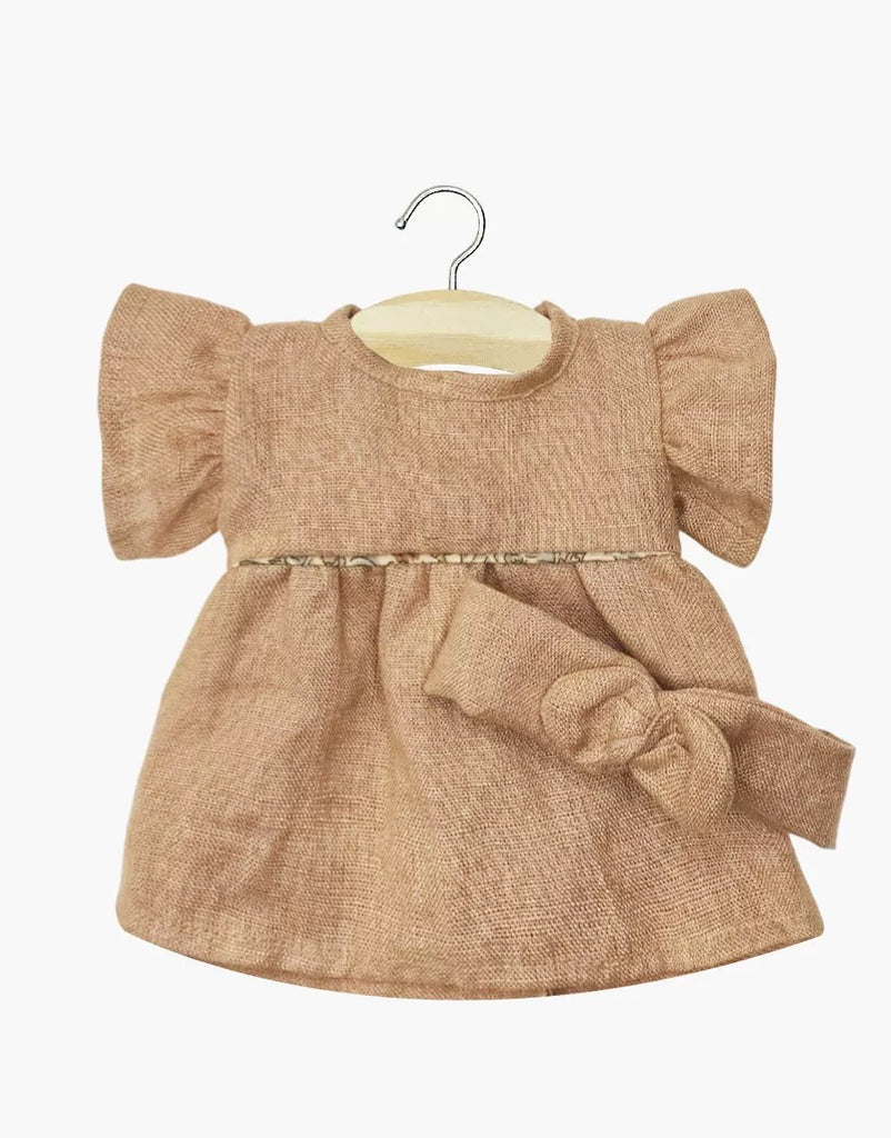 The Minikane Doll Clothing Daisy Dress & Headband in Washed Linen - Hazelnut features a small brown dress with puffed sleeves, fitted waist, and large bow, perfect for 14-inch dolls or Minikane dolls, shown on a wooden hanger.
