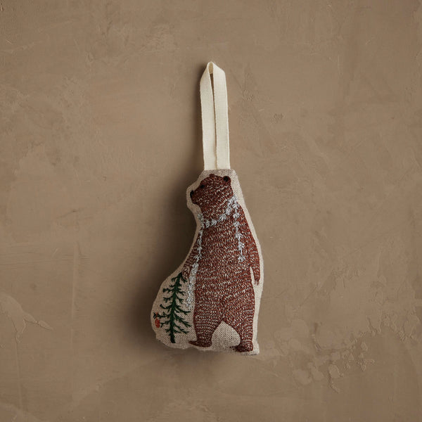 The Coral & Tusk Bear with Tinsel Ornament is a small fabric bear ornament with a cream hanging loop, simple stitched brown bear and green pine tree—ideal as a woodland Christmas decoration or mini tree ornament.