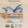The Market Fish Wooden Play Market Crate is a wooden toy crate filled with play fish, perfect for pretend market fun and imaginative role play.