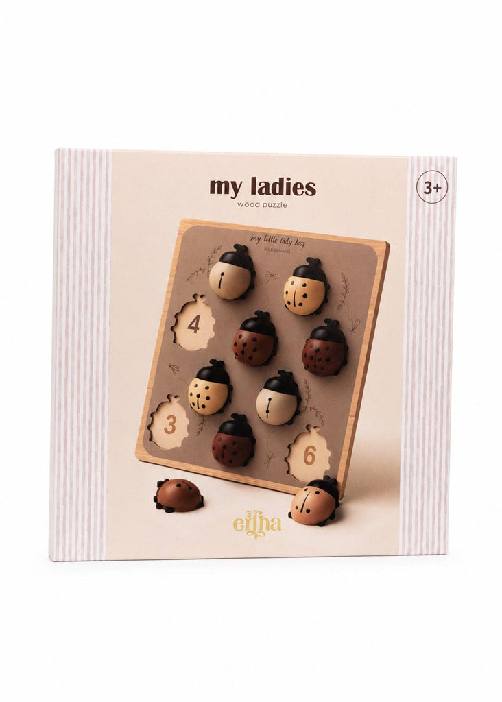 A boxed Montessori-style wooden peg puzzle for ages 3+, branded “elha” and labeled “My Little Lady Bug Wooden Puzzle,” features removable numbered ladybug pieces (3, 4, and 6) on a beige board—a charming counting toy.