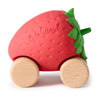 Sweetie The Strawberry Baby Car is an eco-friendly, natural rubber baby toy shaped like a red strawberry with green leaves, two pairs of wooden wheels, and "Oli & Carol" embossed on the side—perfect for little hands.