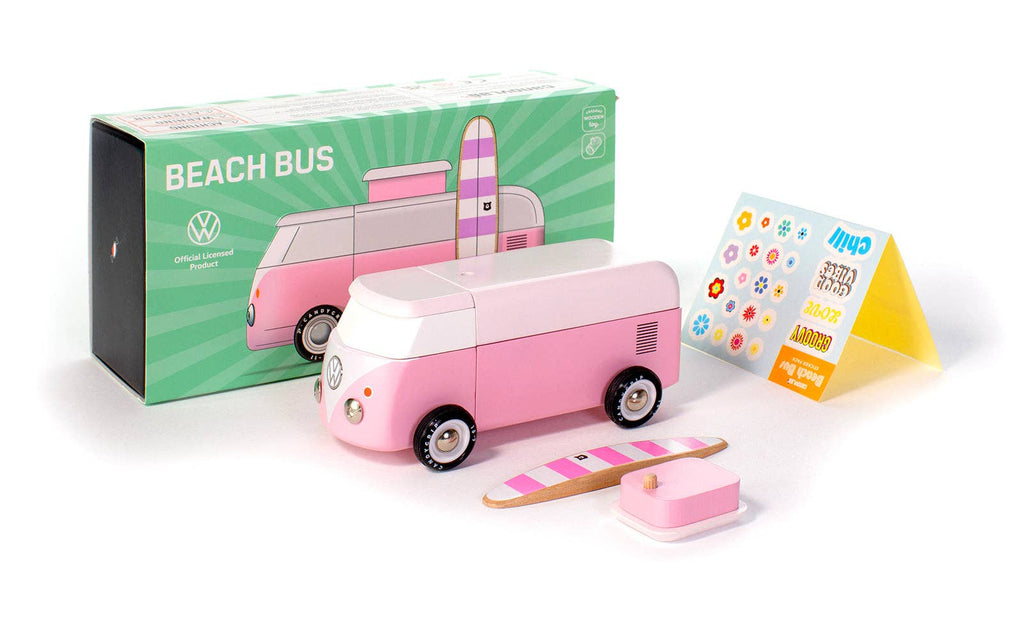 The VW Beach Bus Pink is a pink and white toy van inspired by the Volkswagen Type 2. It includes a surf board, small pink box, "Beach Bus" packaging, sticker sheet, instruction card, and a magnetic camper top.
