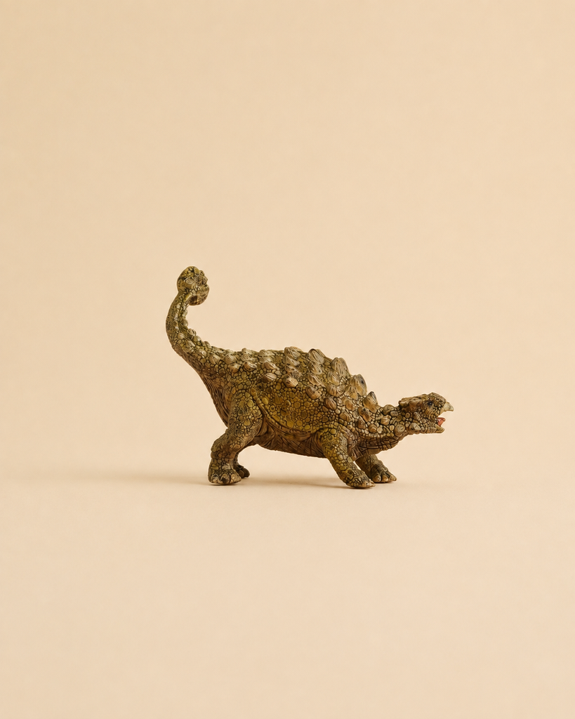A Schleich Ankylosaurus Realistic Dinosaur Toy stands on a plain beige background, facing right with its mouth slightly open and tail raised—an ideal educational figurine for young dinosaur enthusiasts.