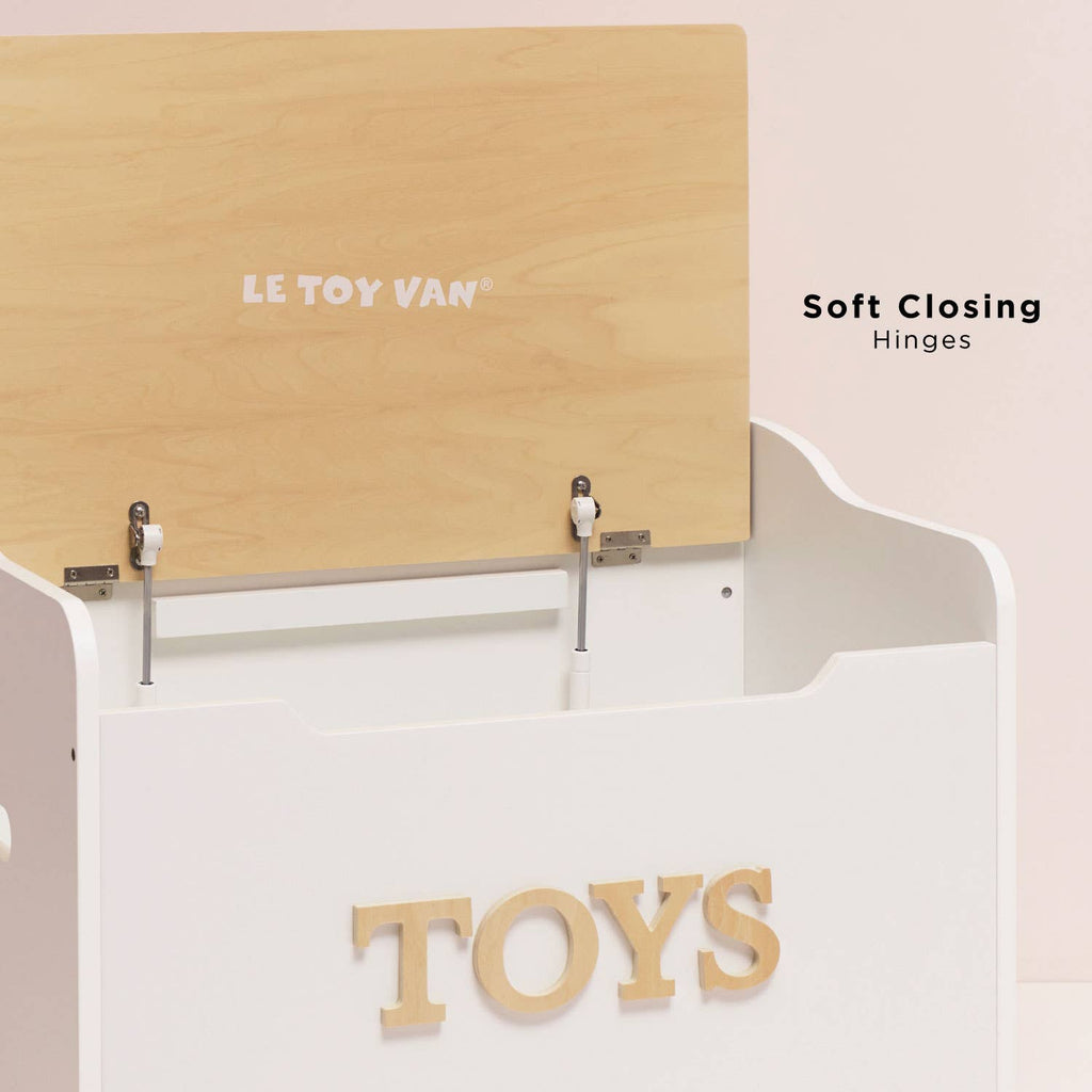 The Toy Storage Box is a white wooden kids storage box with "TOYS" on the front and a light wood lid that's partially open, featuring soft closing hinges. Ideal as toy storage furniture for any playroom. "Soft Closing Hinges" appears on the right.