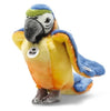 The Steiff Lori Parrot is a colorful plush stuffed animal with blue, yellow, and orange fur, a gray beak, a green patch on its head, and features both a Steiff tag on its chest and another tag on its wing.