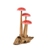 The Small Wooden Red Mushroom Trio features three wooden red mushrooms with white spots and tall wooden stems, all grouped together on a textured, light brown driftwood base. This decorative figurine adds a whimsical touch to any space.