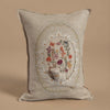 The Coral & Tusk Sugar Egg Pocket Pillow boasts a linen cushion with an embroidered white bear resting in a spring-themed scene of vibrant flowers and mushrooms, framed by an oval of leaves and small white flowers on a beige background.