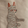 A Halloween-themed Coral & Tusk Costumes Bag features a detailed embroidered fox wrapped in bandages, resembling a mummy. The costumed critter is depicted in profile, facing left, with visible orange fur at the ears and snout against a beige fabric background. Perfect for adding a spooky touch to any Halloween costumes bag.