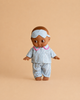 The Minikane Mini Pancha Doll - Noah with Blue Striped Sleepsuit, crafted from high-quality vinyl and featuring blue and white striped pajamas with pink trim and a matching sleep mask, is shown against a plain beige background—perfect for inspiring imaginative play.