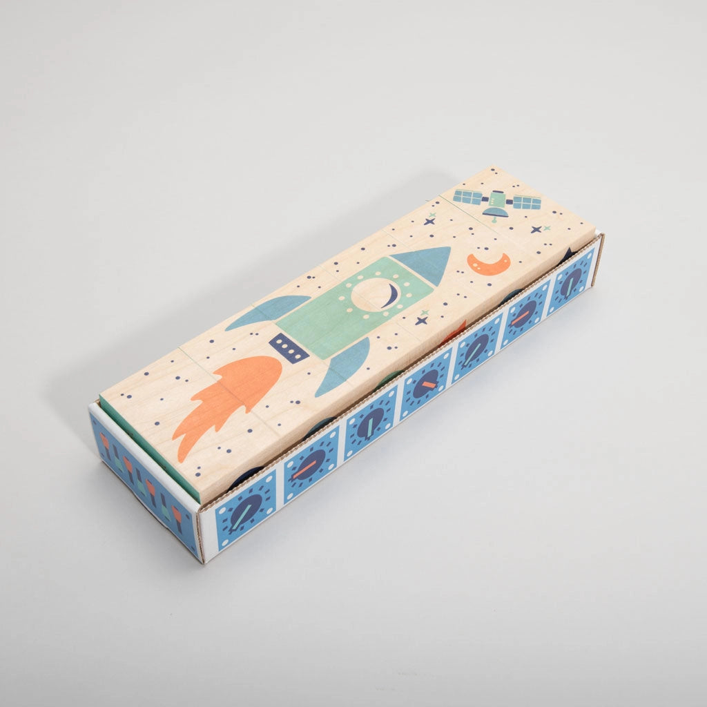 A colorful illustrated Uncle Goose Environments Space Blocks featuring a whimsical rocket ship design with stars and planets, placed on a plain light gray background.