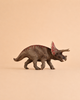 The Schleich Triceratops Dinosaur Toy features a textured brown body with red markings and stands against a plain beige background, making it an ideal educational figurine for collectors and fans of dinosaur toys.