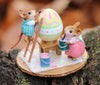 The Wee Forest Folk Tiny Collectible - Colossal Easter Coloring features two hand-sculpted mice: one in green overalls paints a giant egg atop a ladder, while another in a pink dress holds paint beside the egg on a mat over wood.