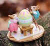 The Wee Forest Folk Tiny Collectible - Colossal Easter Coloring (Not a Toy) features two hand-sculpted mice in colorful outfits painting a large Easter egg outdoors, one on a step stool and the other painting beside it on a tiny mat.