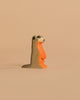 The Handmade Holzwald Meerkat is a small, upright wooden figurine in orange and brown with detailed facial and body accents, photographed against a beige background—an eco-friendly and charming addition to any toy collection.