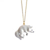 A white fine porcelain Polar Fox Necklace pendant hanging from a 24k gold plated chain, isolated on a white background. The bear is mid-stride with its nose pointed downwards.