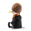 The Steiff Harry Potter Plush 11" features light skin, brown hair, a red and yellow scarf, black coat, and a yellow beak-like detail on its nose, sitting sideways against a white background.
