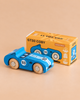 A classic racing toy, the No. 5 GT30 Coby—a blue wooden race car made in England—sits beside a yellow box labeled “GT30 COBY” and “Limited Edition” on a beige background. Crafted as a sustainable wood toy, it offers timeless play and collectible charm.