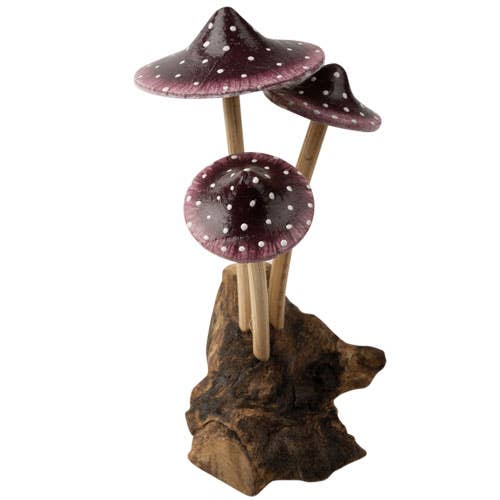 The Small Wooden Purple Mushroom Trio features three charming purple mushrooms with white spots and long stems, growing from a piece of brown driftwood—a delightful decorative figurine perfect for any space.