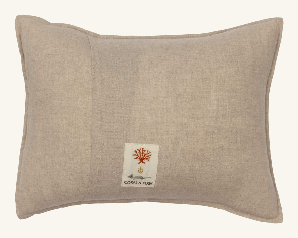 The Christmas Wreath Trio Pocket Pillow—a beige, rectangular linen pillow with a small white tag—features embroidered red coral, an anchor, and "CORAL & TUSK," making it a charming holiday wreath accent or woodland decor.