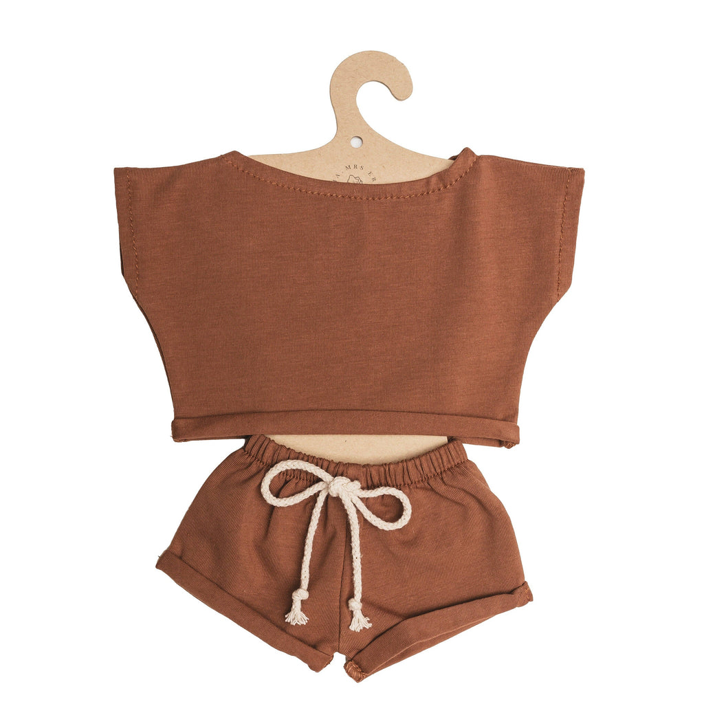 Mrs. Ertha Doll Clothes - 13″-14″ - Rusted Comfy Set features a two-piece brown toddler outfit with a short-sleeve crop top and drawstring shorts, displayed on a hook-shaped cardboard hanger—perfectly sized for Minikane dolls or as charming handmade doll clothes.