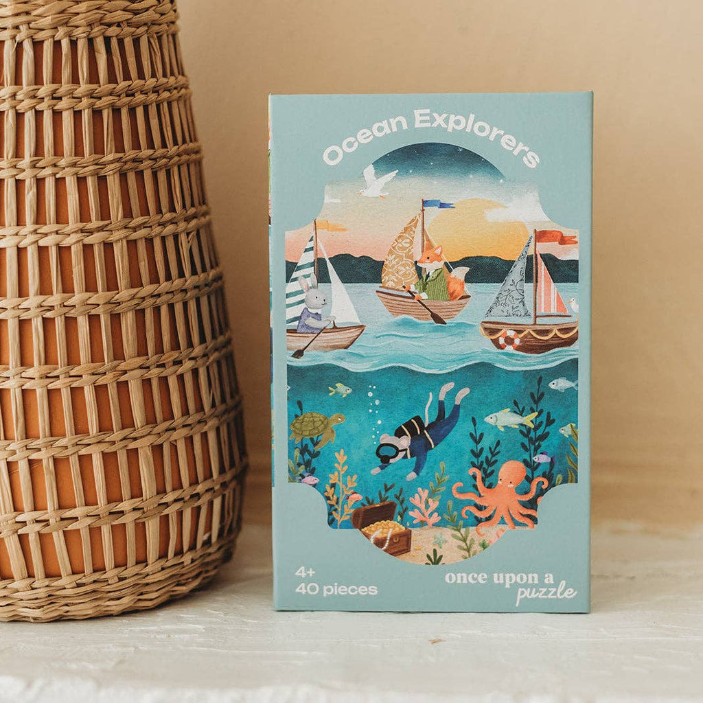 A box labeled “Ocean Explorers 40 Piece Mini” features boats with animals sailing on the water and sea creatures below, and contains a 40-piece kids jigsaw puzzle designed for ages 4 and up.