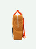 A Sticky Lemon Backpack Large in the Farmhouse color, with bright orange straps and zipper details, displayed against a plain white background. The backpack features side pockets and is made from waterproof nylon, maintaining a modern, sleek design like Homemade Honey.