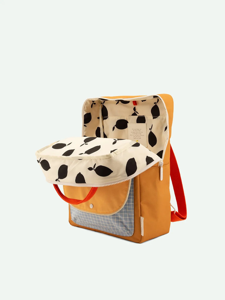 A stylish Sticky Lemon Backpack Large with a beige upper section featuring a black abstract pattern, crafted from waterproof nylon, a solid mustard lower section, and bright red straps, displayed against a plain background.