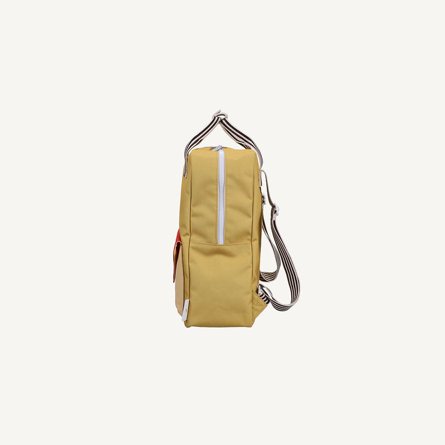 Side view of the Sticky Lemon Backpack Large - Envelope in reed green, featuring a white zipper, striped adjustable shoulder straps, and a red front pocket, displayed on a plain white background. This waterproof kids bag is thoughtfully crafted from recycled PET for durability and sustainability.
