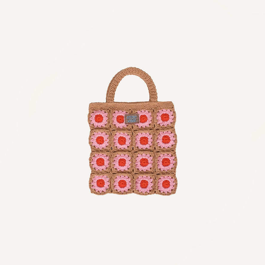 Introducing the Sticky Lemon Crochet Bag - Lemon Tree - Flower - Campfire Orange: a delightful crochet accessory with a tan handle and body, adorned with a playful grid of campfire orange and pink flower squares against a crisp white background. Designed in the signature whimsical style of Sticky Lemon, this bag radiates cheerful vibes and makes the perfect playful carryall for kids.