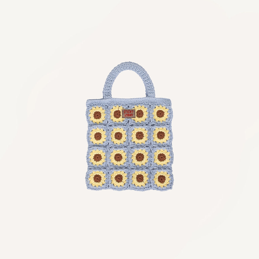 Inspired by Sticky Lemon, the Sticky Lemon Crochet Bag - Lemon Tree - Flower - Willow Basket is a delightful kids’ crochet bag adorned with a blue border and handles, and beautifully decorated with a yellow and brown sunflower grid motif.