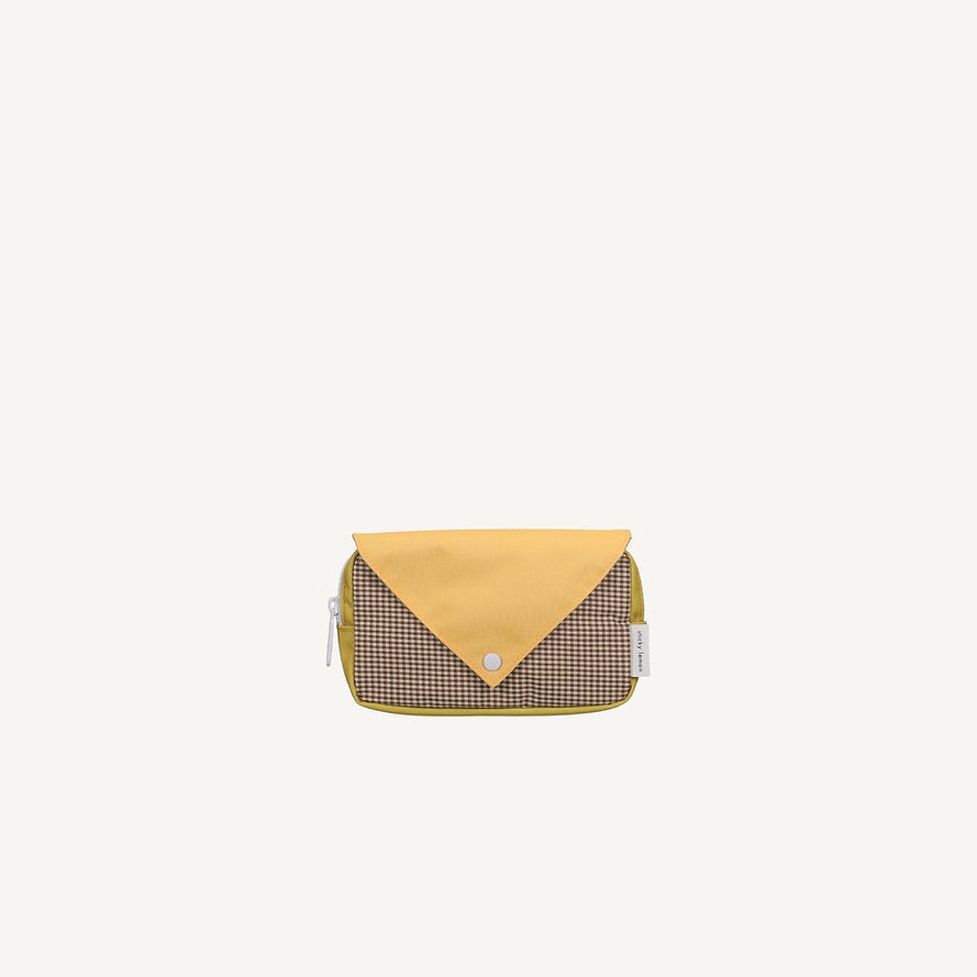 The Sticky Lemon Fanny Pack Small - Envelope - Apple Juice features a brown checkered body and yellow envelope-style flap with a snap button, made from recycled PET bottles and displayed on a plain white background.