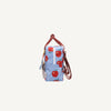 Side view of the Sticky Lemon Backpack Small - Special Edition - Apple Grub: a compact kids’ backpack with red apple prints, brown handles and straps, zipper closure, and made from recycled PET bottles against a light blue background.