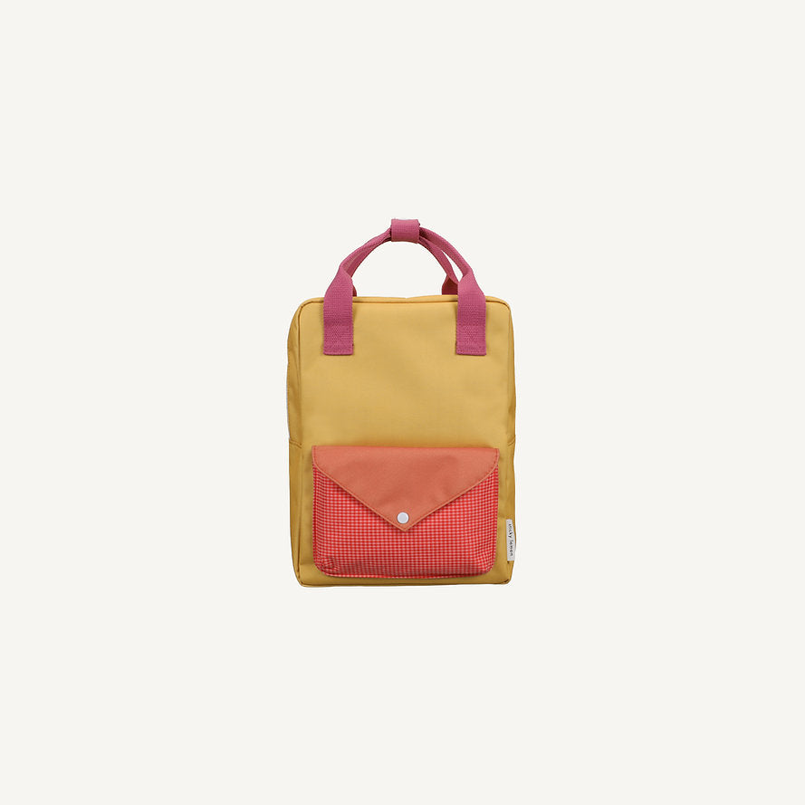 The Sticky Lemon Backpack Medium - Envelope - Apple Grub is a small yellow backpack with pink handles, a front pocket with a red flap and red-and-white checkered pattern, made from recycled PET bottles and featuring a waterproof lining on a plain light background.